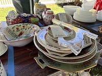 Mixed stack of plates, platter, acrylic stands and large Asian bowl on table