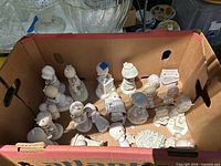 Top view of all Precious Moments porcelain figurines inside cardboard box