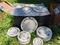 Stacks of dinner and salad plates plus charger displayed outdoors