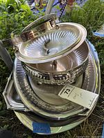 Stacked view of platter, covered bowl with lid, small tray
