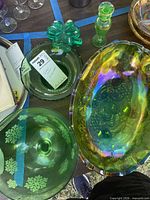 Overhead of all green glass pieces showing compote, oval dish, clover box, bud vase, scalloped bowl