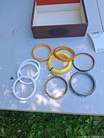 All eight bangles laid out beside box