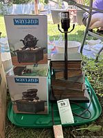 Two boxed Wayland fountains and stacked-book lamp on tray