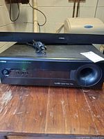 Front view of Yamaha SA-300 receiver with SR-300 soundbar resting on top, power cord visible
