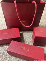 Bag and three red Cartier boxes