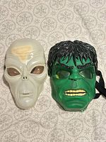 Front view of both masks: Hulk and white alien