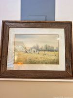 Framed watercolor painting in rustic wood frame on wall