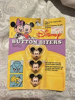 Front view of sealed Disney Button Biters card showing full packaging