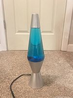 Full view of lava lamp showing silver base, blue liquid