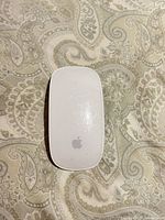 Top view of Apple Magic Mouse showing white surface and Apple logo