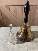 Brass bell and crystal bell standing upright