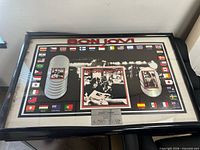 Front view of framed Bon Jovi display showing graphics, plaque, frame condition