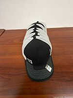 Stack of six identical black and white CAT Foley Inc trucker caps