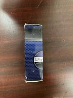 Front view of rectangular First Trust blue/black box showing logo and wear