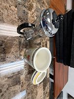 French press lying next to ceramic canister and lid showing materials and overall condition