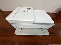 Front angled view of closed HP white all-in-one printer