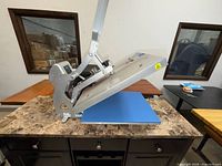 Heat press open showing platen and blue pad