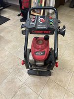 Front view of Troy-Bilt pressure washer showing control panel, frame, red engine cover