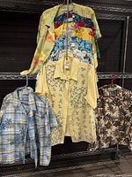 Front view of eight assorted summer tops on rack