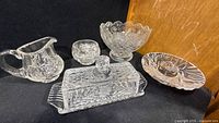 group shot of five clear pressed glass pieces