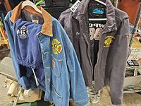 Carhartt denim jacket, Tri-Mountain charcoal jacket and navy sweatshirt on hangers