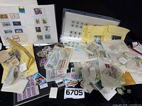 Overview of lot showing numerous loose stamps, album pages, envelopes and packets