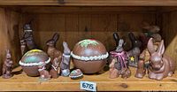 Shelf with all ceramic bunny figurines and faux chocolate eggs