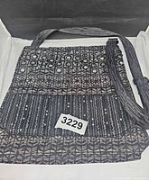 Full view of Maruca crossbody handbag showing pattern, size reference tag, adjustable strap