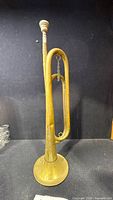 Full view of brass bugle standing upright