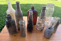 Group shot of all ten dug glass bottles on table