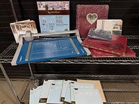 Overall lot on shelving showing trimmer, albums, wire stand box, and page protector packs