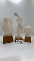 Front view of all three plaster busts on wood bases
