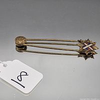 Full view of gold-tone heraldic crest brooch