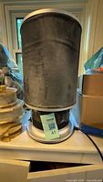 Full view of cylindrical air purifier with dust on filter sleeve