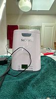 Front view of SoClean unit showing branding, lid, and power adapter cord