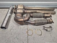 Overall lot showing catalytic converter, two flex pipes, two straight pipes, sleeve pipe, gaskets and bracket