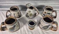 Group shot of four mugs, creamer and egg cup