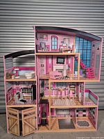 Full front view of multi-level KidKraft dollhouse with accessories in place