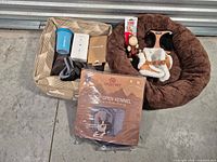 All items overview on floor including beds, boxed kennel, grooming tools, harnesses, collar, tracker, toy