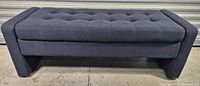 Front view of navy tufted storage bench ottoman