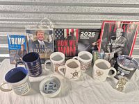 Group shot of all items displaying books, mugs, calendar, magazine, ashtray, playing cards, tumbler, pins