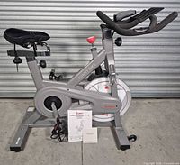Full left-side view of SF-B1851 bike with seat cover, bottle holder, manual on floor