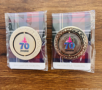 Front view of two Disneyland 70 VIP Tour pins on plaid backing cards