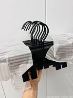 Bundle of black wooden hangers wrapped in foam