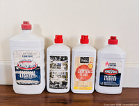 Front view of four lighter fluid bottles lined up