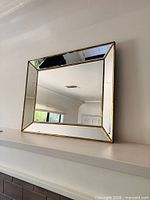 Front view showing beveled mirror and gold-tone trim