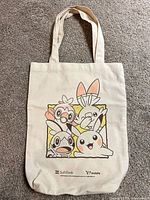 Full view of tote bag front showing artwork and handles