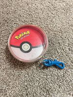 Top view of Poké Ball card case on carpet