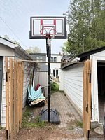 Full view of hoop showing backboard, rim, pole and base