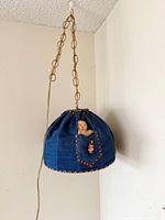 Full view of denim lamp hanging from ceiling with chain and cord